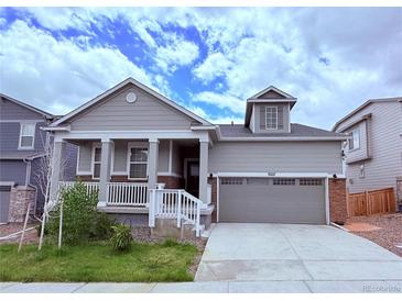 Charming gray two-story home with a covered front porch and two car garage at 9227 Salida St, Commerce City, CO 80022
