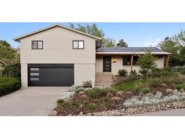 Charming split-level home featuring a modern two-car garage and beautifully landscaped front yard at 1931 Foothills Rd, Golden, CO 80401