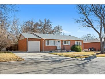 Charming red brick single story home featuring a attached garage, green front lawn, and mature trees at 6359 Brooks Dr, Arvada, CO 80004