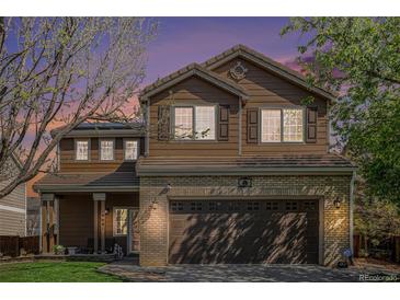 Charming two-story home with a brick-accented garage and well-maintained landscaping at 19681 E 59Th Pl, Aurora, CO 80019