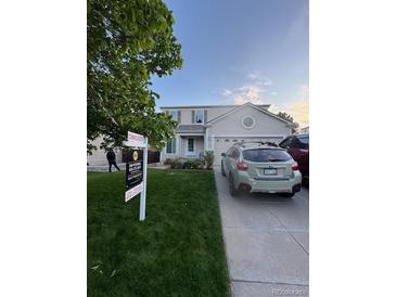 Charming two-story home features a well-manicured lawn and an attached two-car garage at 19410 E Ithaca Pl, Aurora, CO 80013
