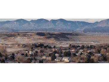 Scenic view of the community featuring golf course homes nestled against a backdrop of majestic mountains at 3299 S Newcombe St, Lakewood, CO 80227