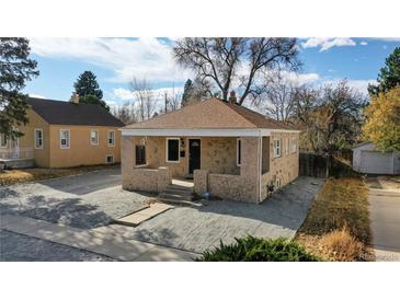 Charming home with a front yard, beautiful stonework, covered porch and fresh gravel at 1621 Trenton St, Denver, CO 80220