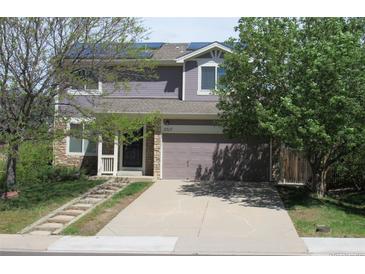 Charming two-story home with a well-manicured lawn, a stone pathway, and a two-car garage at 2517 S Genoa St, Aurora, CO 80013
