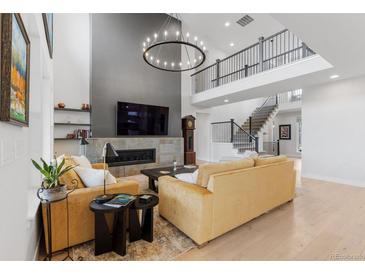 Bright living room boasts fireplace, hardwood floors, and elegant chandelier at 7077 Copper Sky Cir, Castle Pines, CO 80108