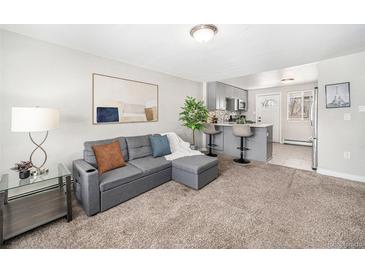 Inviting living room featuring plush carpet, a comfortable sofa, and an open flow to the kitchen and breakfast bar at 4810 W 8Th Ave, Denver, CO 80204