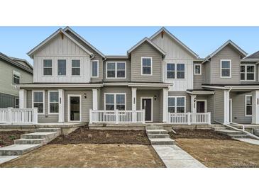 A charming two-story townhome with a welcoming front porch and manicured landscaping at 702 N Bently St, Watkins, CO 80137
