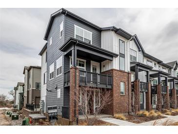 Modern townhome with gray siding, brick accents, and covered porch at 1342 Independence St # 6, Lakewood, CO 80215