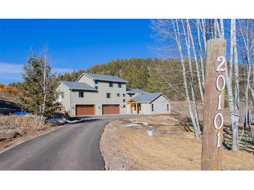 Two story home with a three car garage situated on a large lot with mature trees and mountain views at 20101 Spring Gulch Rd, Morrison, CO 80465