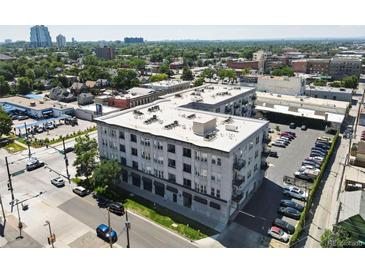 An aerial view of the apartment building shows parking and green space in a vibrant urban setting at 277 N Broadway # 403, Denver, CO 80203