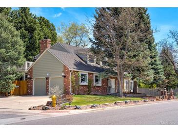 Charming two-story brick home with a well-manicured lawn, mature trees, and an attached two-car garage at 6302 S Ivy Ct, Centennial, CO 80111