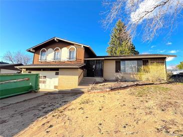 Two-story home featuring brick and brown siding, an attached garage, and a front yard at 7345 E Hinsdale Pl, Centennial, CO 80112