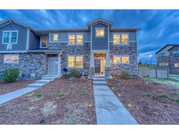 Attractive townhome showcases stone and siding exterior, plus manicured landscaping at 24806 E Calhoun Pl # A, Aurora, CO 80016