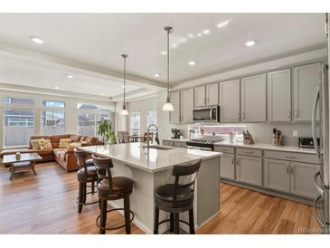 Modern kitchen with a large island, pendant lighting, and stainless steel appliances at 4478 Riviera Ct, Aurora, CO 80019