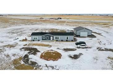 Aerial view of a house, detached garage, and expansive land at 43620 E 80Th Ave, Bennett, CO 80102