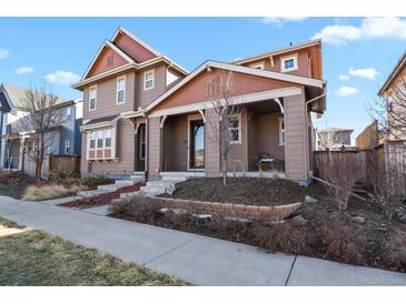 Charming two-story home with a covered front porch and well-manicured landscaping at 7976 E 53Rd Dr, Denver, CO 80238