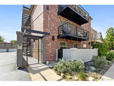 Charming brick apartment building featuring inviting balconies and a secure gated entrance at 529 N Washington St # 304, Denver, CO 80203