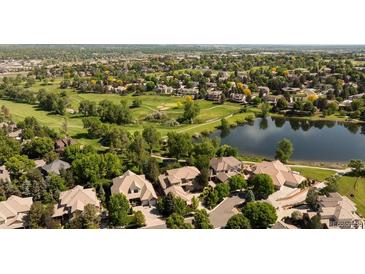 Aerial view of homes and golf course, surrounded by lush green trees and a lake at 2535 W 115Th Dr, Westminster, CO 80234