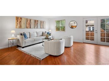 Bright living room features modern furnishings, hardwood floors and access to the outdoors at 7755 E Quincy Ave # T48, Denver, CO 80209