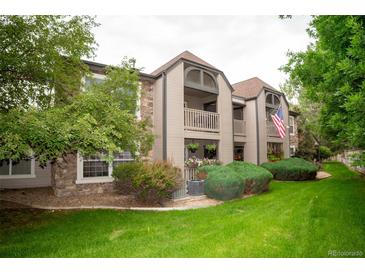 Inviting condo exterior featuring a lush lawn and two-story facade with quaint balcony at 9263 E Arbor Cir # B, Englewood, CO 80111