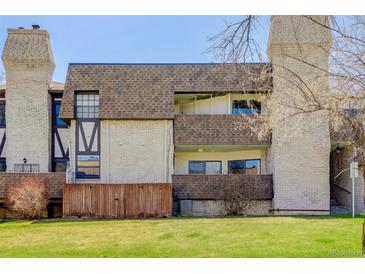 Three-story condo with brick facade, private patios, and well-maintained landscaping at 7201 E Quincy Ave # 103, Denver, CO 80237