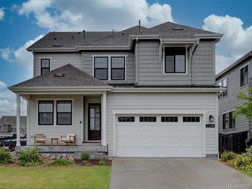 Charming two-story home with a two car garage, attractive gray siding, and well-maintained landscaping at 11246 Bellsong Ln, Littleton, CO 80125