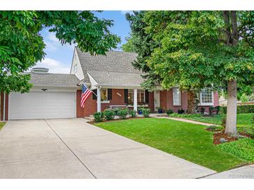 Charming brick home featuring a well-manicured lawn, mature trees, and an inviting covered front porch at 3450 E Easter Ave, Centennial, CO 80122