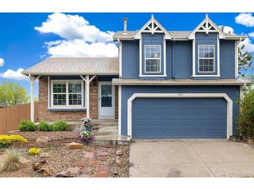 Charming two-story home features a blue exterior, attached garage, and manicured landscaping at 325 Mulberry Cir, Broomfield, CO 80020