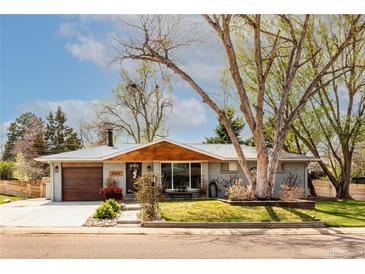 Charming single-story home with a beautifully landscaped front yard and mature trees at 6045 S Cook St, Centennial, CO 80121