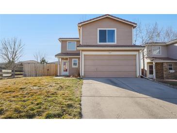 Charming two-story home featuring a two-car garage, a cozy front porch, and a well-maintained lawn at 3829 Odessa St, Denver, CO 80249