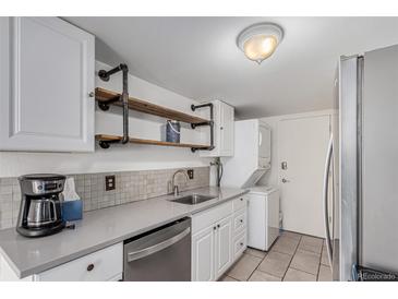 Bright kitchen with modern appliances, laundry machine and custom shelving at 7904 Chase Cir # 146, Arvada, CO 80003