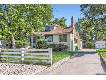 Charming home with a white picket fence, mature trees, and a long driveway at 3246 W 53Rd Ave, Denver, CO 80221