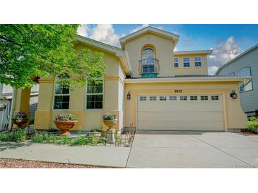 Charming stucco home featuring an attached two-car garage and delightful curb appeal with flower boxes at 9832 N Crystal Lake Dr, Littleton, CO 80125