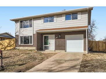 Charming two-story home featuring brick accents, white trim, and a well-maintained front yard with attached garage at 5153 Scranton St, Denver, CO 80239