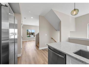 Modern kitchen featuring stainless steel appliances, quartz countertops, and light hardwood flooring at 2140 S Ash St # 105, Denver, CO 80222