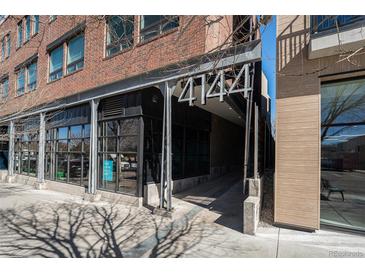 Modern brick building featuring sleek architectural details and prominent street-facing signage at 4144 Tennyson St # 212, Denver, CO 80212