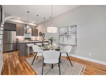 Stylish dining area with modern lighting, seating, and a view into the adjacent kitchen at 4144 Tennyson St # 212, Denver, CO 80212