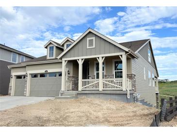 Charming home featuring a welcoming front porch, complemented by a two-car garage and stone accents at 3895 Buttongrass Trl, Castle Rock, CO 80108