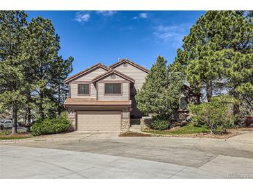 Charming two-story home with attached garage, mature trees, and landscaped front yard at 187 W Prestwick Ct, Castle Rock, CO 80104