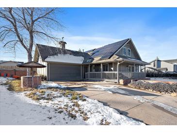 Gray exterior house with solar panels and a partially snow-covered driveway at 8845 S Brentwood St, Littleton, CO 80128