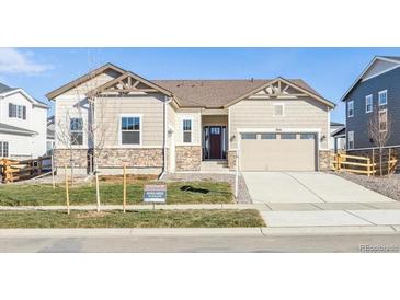 Two-story house with beige siding, a three-car garage, and a landscaped front yard at 3816 N Elk St, Aurora, CO 80019