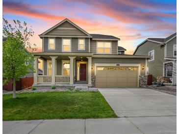 Charming two-story home with a well-maintained lawn, a covered front porch, and a two car garage at 14850 Oslo Ave, Parker, CO 80134