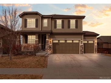 Charming two-story home with stone accents, three-car garage, and manicured front yard at 17077 E 111Th Ave, Commerce City, CO 80022