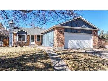 Charming home featuring brick accents, blue siding, mature trees, and a two-car garage at 20091 E Bellewood Dr, Centennial, CO 80015