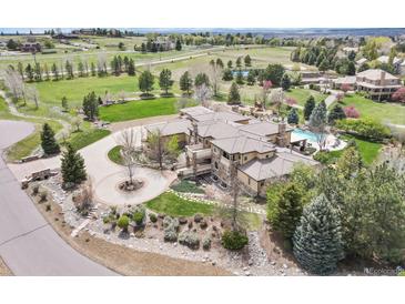 Expansive estate aerial view features a circular driveway, manicured lawn, swimming pool and lush landscaping at 7390 Sagebrush Dr, Parker, CO 80138