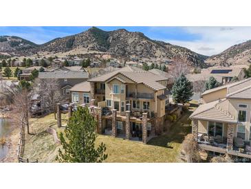 Beautiful two-story home with a tile roof, multiple balconies, stone columns, and mountain views at 16323 River Haven Way, Morrison, CO 80465