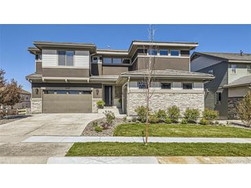 Contemporary two-story home featuring a manicured lawn and a two-car garage at 16345 Spanish Peak Way, Broomfield, CO 80023