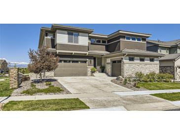 Stunning exterior showcasing the home's architecture, landscaping, and mountain views in the distance at 16345 Spanish Peak Way, Broomfield, CO 80023