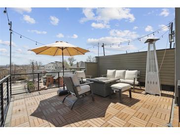 Inviting rooftop deck with stylish furniture, a cozy fire pit, and city views, perfect for outdoor entertaining at 2624 N Clay St, Denver, CO 80211