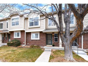 Charming townhouse with a brick facade, manicured lawn, and mature tree providing curb appeal at 18397 E Alabama Pl # D, Aurora, CO 80017
